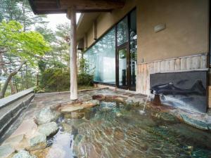 a pond in the middle of a house with a fireplace at Jodogahama Park Hotel in Miyako
