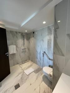 a bathroom with a toilet and a glass shower at BOUMERDES PLAZA Hôtel & Spa in Boumerdes
