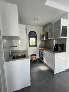 a kitchen with white cabinets and a sink at Miami Beach Puerto Rico in Mogán