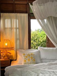 1 dormitorio con 1 cama blanca y ventana en Suksamer Relaxation Homestay, 