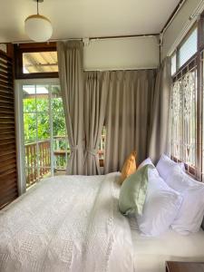 a bedroom with a bed with white pillows and a window at Suksamer Relaxation Homestay 