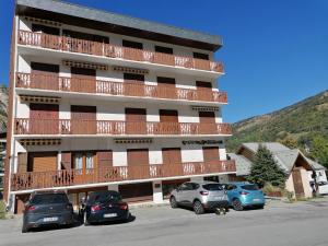 a apartment building with cars parked in a parking lot at Steph et Caro Studio Les Cassettes in Valloire