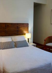 Un dormitorio con una gran cama blanca y una lámpara en Hostal de la Plaça - Hotel Boutique, en Cabrils