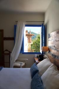a bedroom with a bed and a large window at Hostal de la Plaça - Hotel Boutique in Cabrils