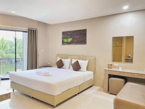 a bedroom with a large bed and a balcony at The Coconut Hotel in Lampang +14 photos