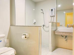 a bathroom with a toilet and a sink at The Coconut Hotel in Lampang