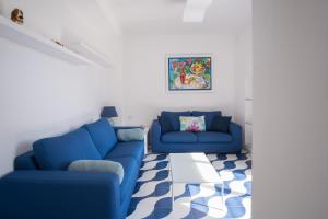a living room with two blue couches and a rug at Villa Sterlizia in Capri
