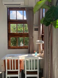 uma sala de jantar com uma mesa e uma janela em Suksamer Relaxation Homestay 