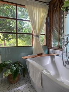 e bagno con finestra e vasca. di Suksamer Relaxation Homestay 