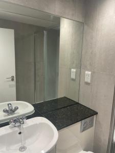 a bathroom with a sink and a mirror at London City 1 Bed with Roof Terrace in London