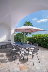 a table and chairs with an umbrella on a patio at Villa Sterlizia in Capri