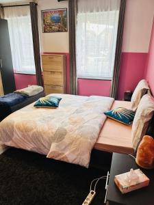 a bedroom with a large bed with two pillows on it at Bien-être-Au-calme et parking gratuit in Seraing