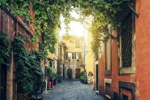 an alley in an old town with the sun shining at DomusLu' - Casa di charme nel cuore di Roma in Rome