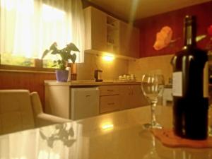 a bottle of wine sitting on a counter with a wine glass at Planinska kuća ,,Furtula" Jahorina in Pale