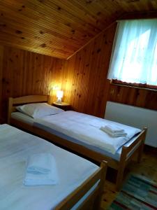 1 dormitorio con 2 camas en una habitación de madera en Planinska kuća ,,Furtula" Jahorina, en Pale