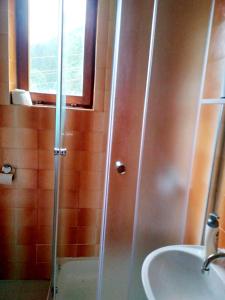 y baño con ducha y lavamanos. en Planinska kuća ,,Furtula" Jahorina, en Pale