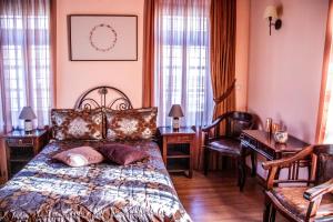 a bedroom with a bed and a desk and chairs at Archontiko Geki 1876 in Papigko