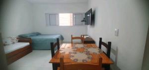 ein kleines Zimmer mit einem Tisch und einem Bett in der Unterkunft Aconchegante no Condomínio da Fê in Cachoeira Paulista