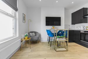 uma cozinha com mesa e cadeiras num quarto em Modern 3 and 2 bedroom apartment in Maida Vale em Londres