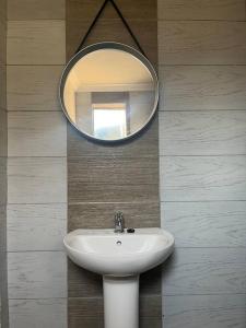 a bathroom with a sink and a mirror on a wall at Cosy and Serene Environment in Boksburg