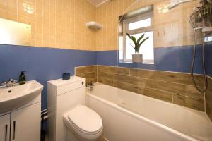 a bathroom with a toilet and a tub and a sink at Sea Downs - moments from beach in Eastbourne +14 photos