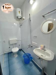 bagno con lavandino, servizi igienici e specchio di iKyam (The Backpackers Hostel/Homestay) a Madikeri