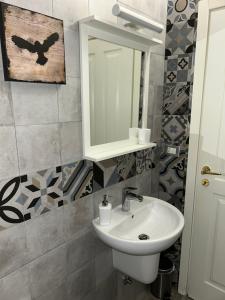 een badkamer met een wastafel en een spiegel bij AM's Apartment in La Spezia