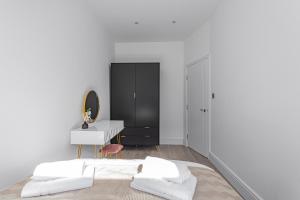 um quarto com 2 camas, uma secretária e um espelho. em Modern 3 and 2 bedroom apartment in Maida Vale em Londres