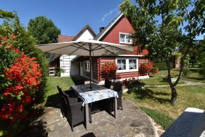 a table with an umbrella in front of a house at Chalupa Alexandra in Kacanovy