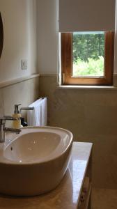 La salle de bains est pourvue d'un lavabo blanc et d'une fenêtre. dans l'établissement Pensiunea Tudorilor, à Văleni-Stînişoara