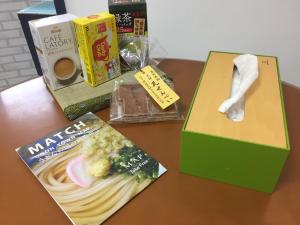 une table avec une boîte de nourriture et un livre dans l'établissement INARI - Vacation STAY 87349, à Takamatsu