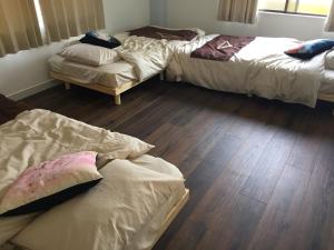 高松市にあるINARI - Vacation STAY 87349のベッド3台が備わるウッドフロアの客室です。