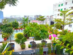 a balcony filled with potted plants and trees at Annex Suites Bogra - CityCentre in Bogra