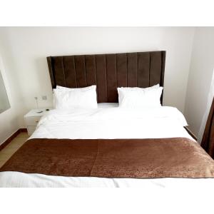 um quarto com uma grande cama branca e uma cabeceira em madeira em Dream Villa em Ongata Rongai 