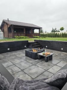 une terrasse avec un foyer extérieur et une maison dans l'établissement Domek całoroczny MAGJAN z sauną, à Złotów