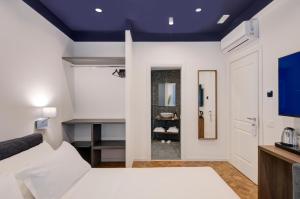 una camera con letto bianco e soffitto blu di Well Suites - Piazza dei Martiri a Napoli