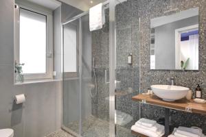 Un baño con ducha de cristal y lavabo. en Well Suites - Piazza dei Martiri, en Nápoles 52 fotos más