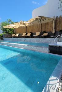 a swimming pool with chairs and umbrellas in a resort at My Son Boutique Hotel & Spa Hoi An in Hoi An