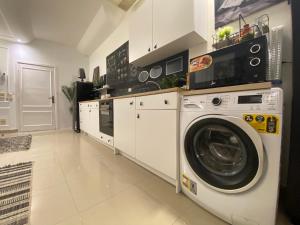 a white kitchen with a washer and dryer in it at The Pyramid Area Vibe in Cairo