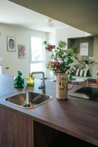 a kitchen counter with a sink and a vase of flowers at JOST Hotel Montpellier Centre St Roch in Montpellier