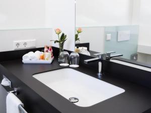 een badkamer met een witte wastafel en een spiegel bij Hotel am Markt in Wipperfürth