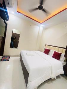 a bedroom with a white bed with a ceiling at Hotel Grill inn in Lucknow