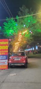 een rode auto geparkeerd op een straat 's nachts bij Hotel Grill inn in Lucknow