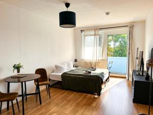 a bedroom with a bed and a table and a window at Modernes Apartment Nähe Chemnitz in Neukirchen
