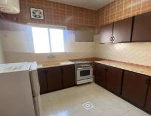 uma pequena cozinha com um fogão e um lavatório em العنوان للوحدات المخدومة ALanwaan of the units served em Dammam