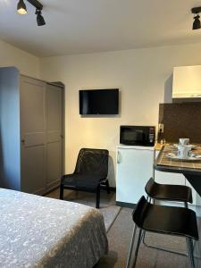 a hotel room with a bed and a table and a kitchen at Impasse 3 in Fosses-La-Ville