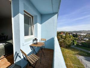a balcony with two chairs and a table and a window at Modernes Apartment Nähe Chemnitz in Neukirchen