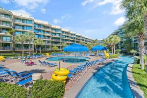 a resort with a pool with chairs and umbrellas at Phoenix on the Bay 1228 in Orange Beach
