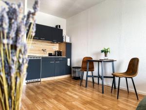 a kitchen with a table and chairs in a room at Modernes Apartment Nähe Chemnitz in Neukirchen