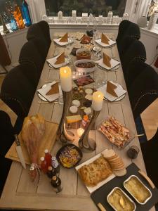 a long wooden table with food and candles on it at BraMy Apartments The LUX View in Tromsø